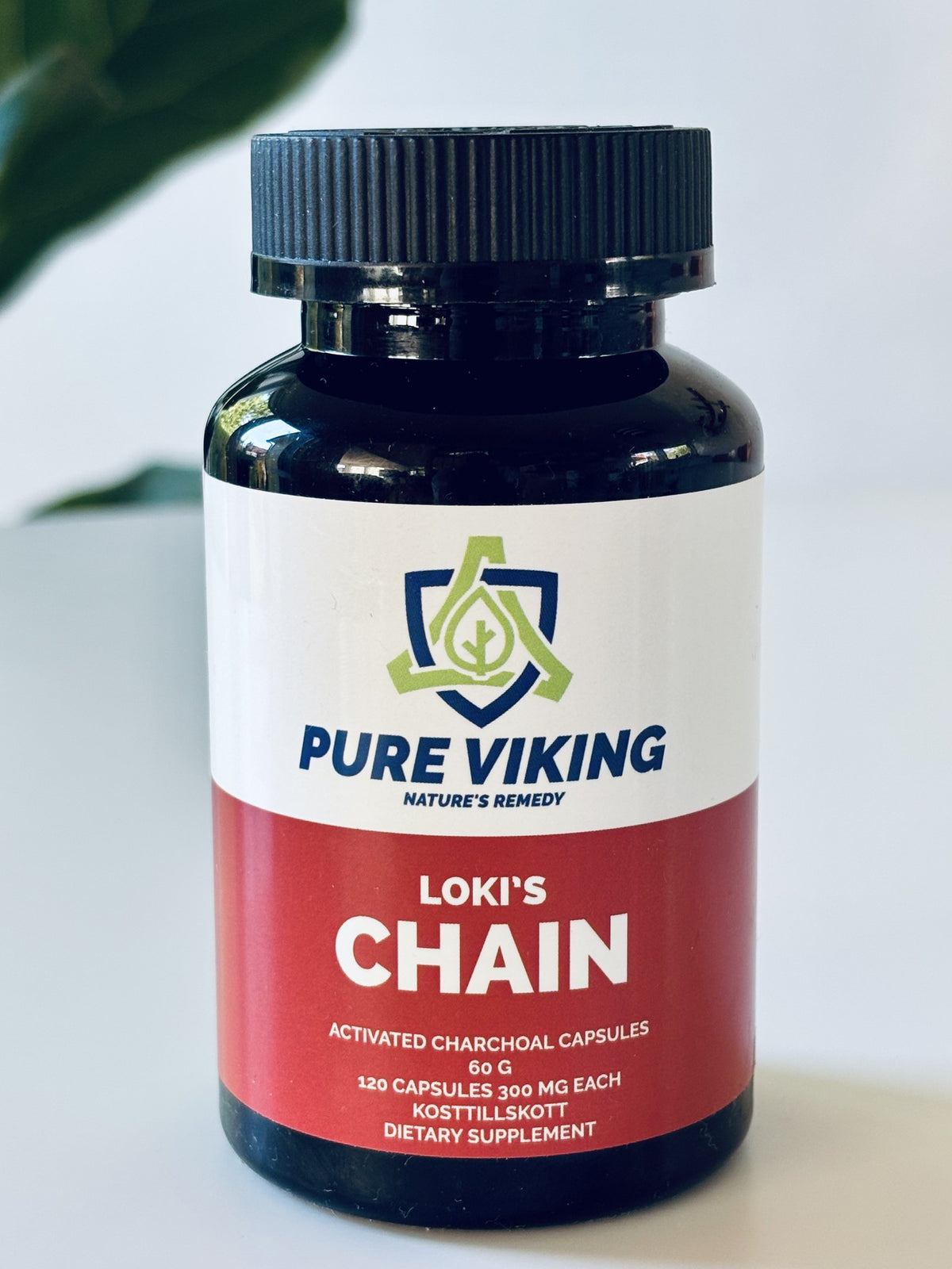 Loki's Chain aktivt kol-kapslar, mörk burk med 120 kapslar à 300 mg och röd och vit etikett på vitt bord