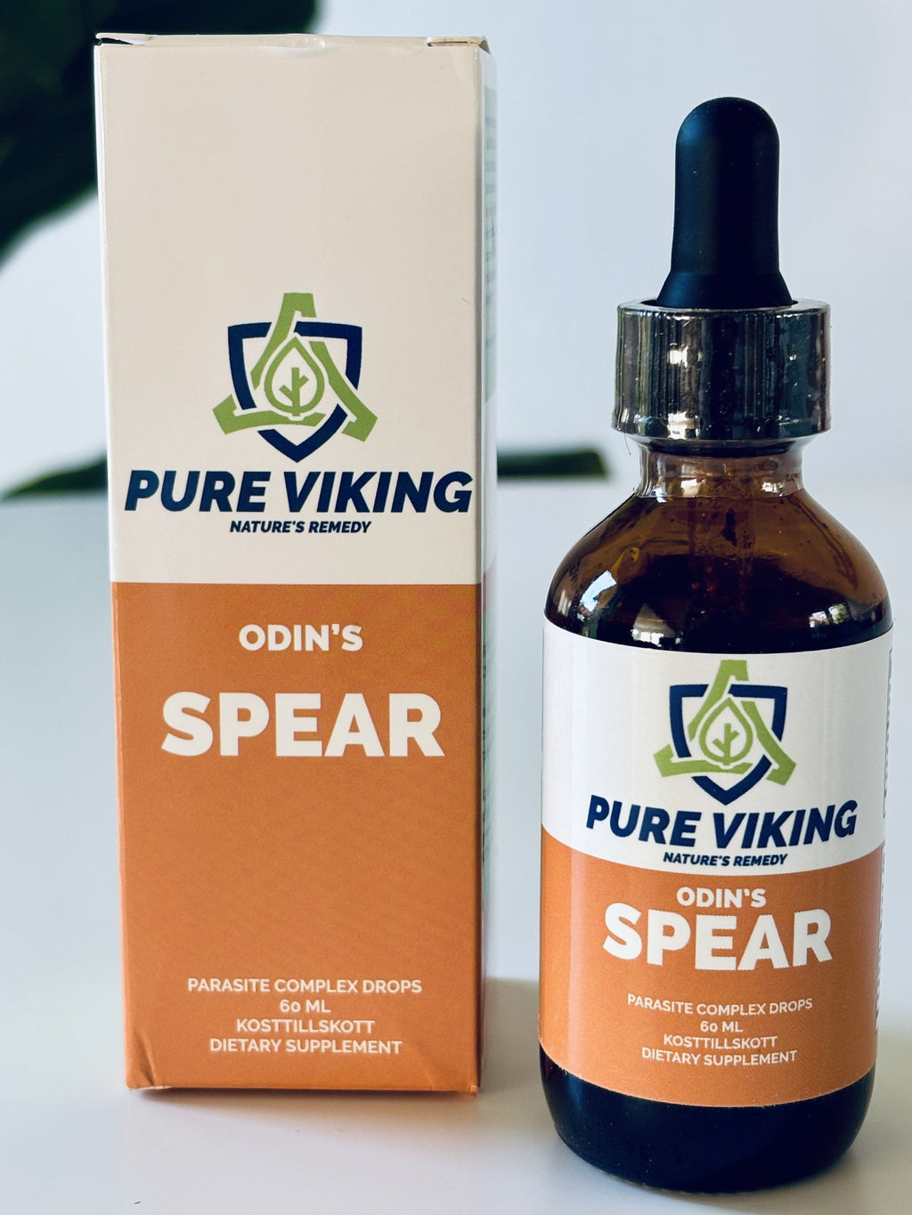 Odin's Spear örtdroppar, 60 ml brun glasflaska med pipett bredvid orange och vit kartong på vitt bord