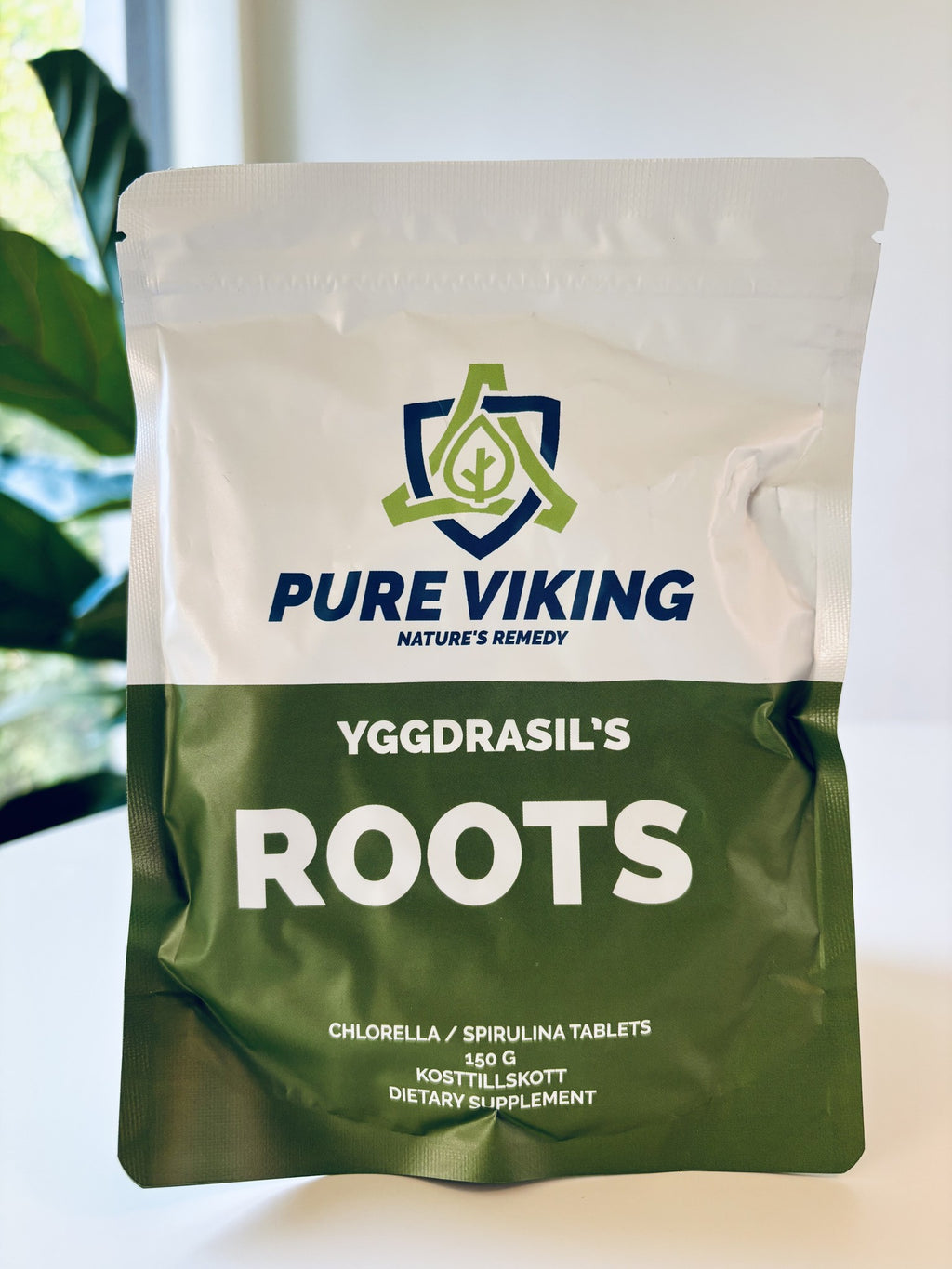 Yggdrasil's Roots chlorella- och spirulinatabletter, 150 g grön och vit påse med Pure Viking-logga framför gröna växter
